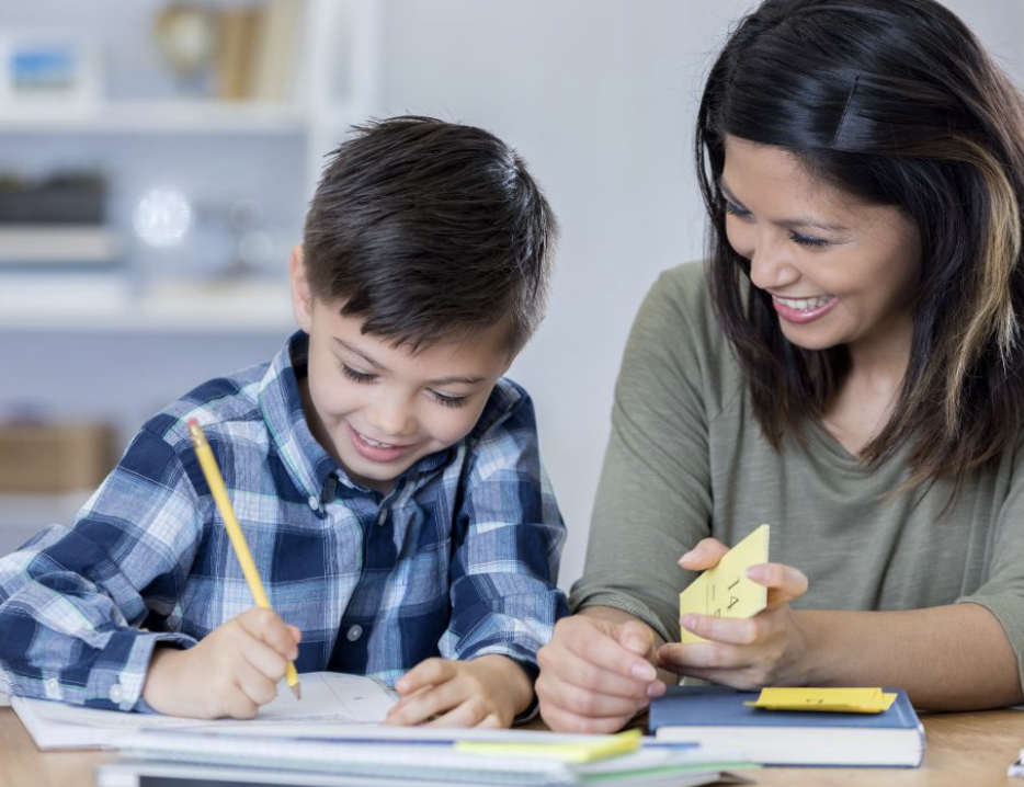 The happy mother and son studying together and mom teaching son to read. 